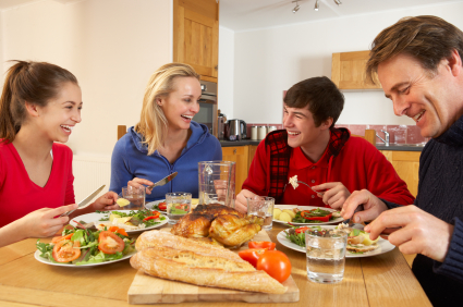 Teenage Family Eating Lunch Together In Kitchen